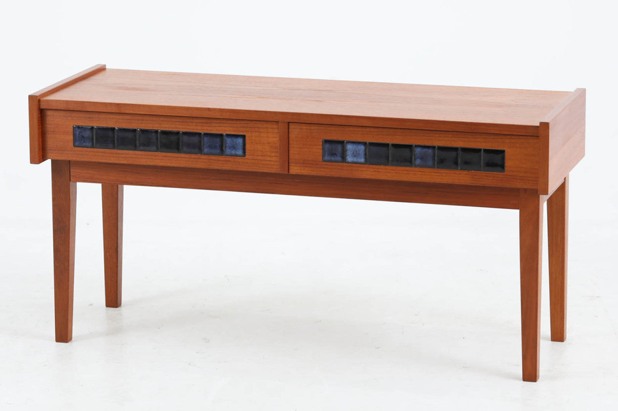 こちらは、北欧より買い付けたワイドチェストです。優れた品質のチーク材を本体に使用し、引き出し前板には鮮やかなブルーのタイルが施されており、デザインのアクセントとなっています。また、左右に取り付けられた細身のテーパー脚が、全体に洗練された印象を与えています。幅90cmのワイドサイズなので、ローボードやセンターテーブルとしてもお使いいただけます。