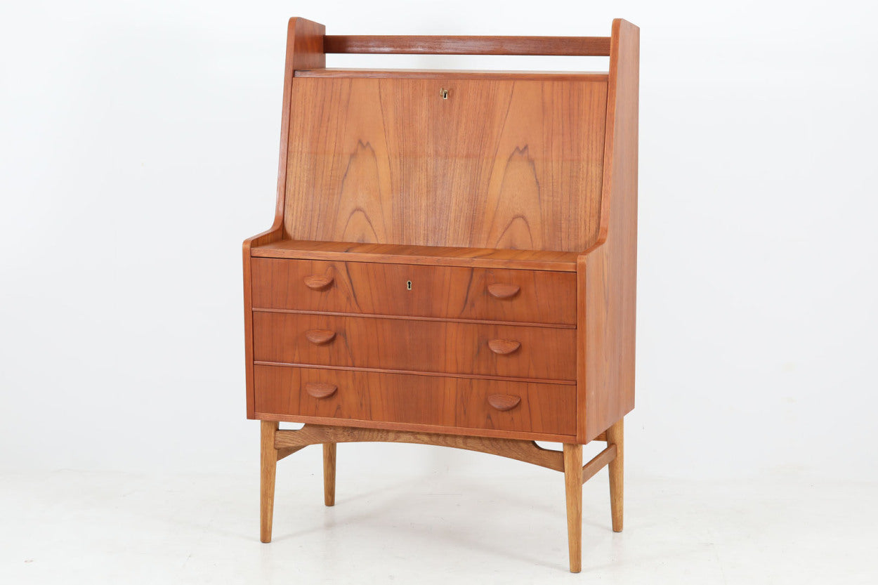 北欧より買い付けたライティングビューロです。ビンテージ家具の中でも造りがよく、デザイン性の高い物となります。1960年代に作製された物と思われますが、本体には良質なチーク材が使用されており、綺麗な木目を楽しんでいただけるのではないでしょうか。脚部にはナチュラルなオーク材が使用されており、開き戸の機能面とあいまってすっきりとした印象に仕上がっています。