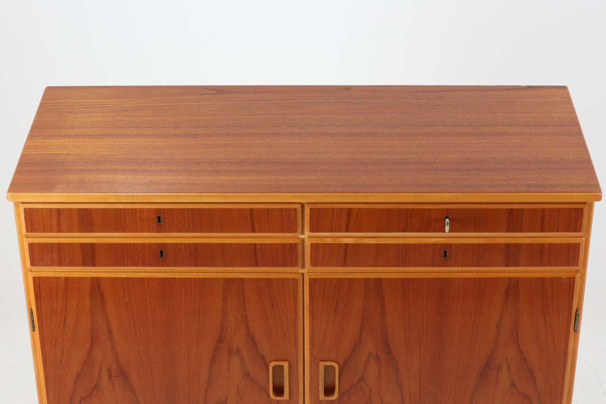 スウェーデンより買い付けた収納キャビネットです。上段の引き出しは鍵を取手として使用する北欧家具ならではのデザインです。大きな開き戸内には書類が入れやすそうな引き出しがございます。収納内部の引き出しは収納する物によって引き出しの位置を変えたり、引き出し自体を取り外してしまうことが可能で非常に使い勝手が良いと思います。本体には良質なチーク材が使用されており温かみのある風合いです。脚や取手、本体の縁にはビーチ材が使用されており、スウェーデン家具ならではのデザインになっています。