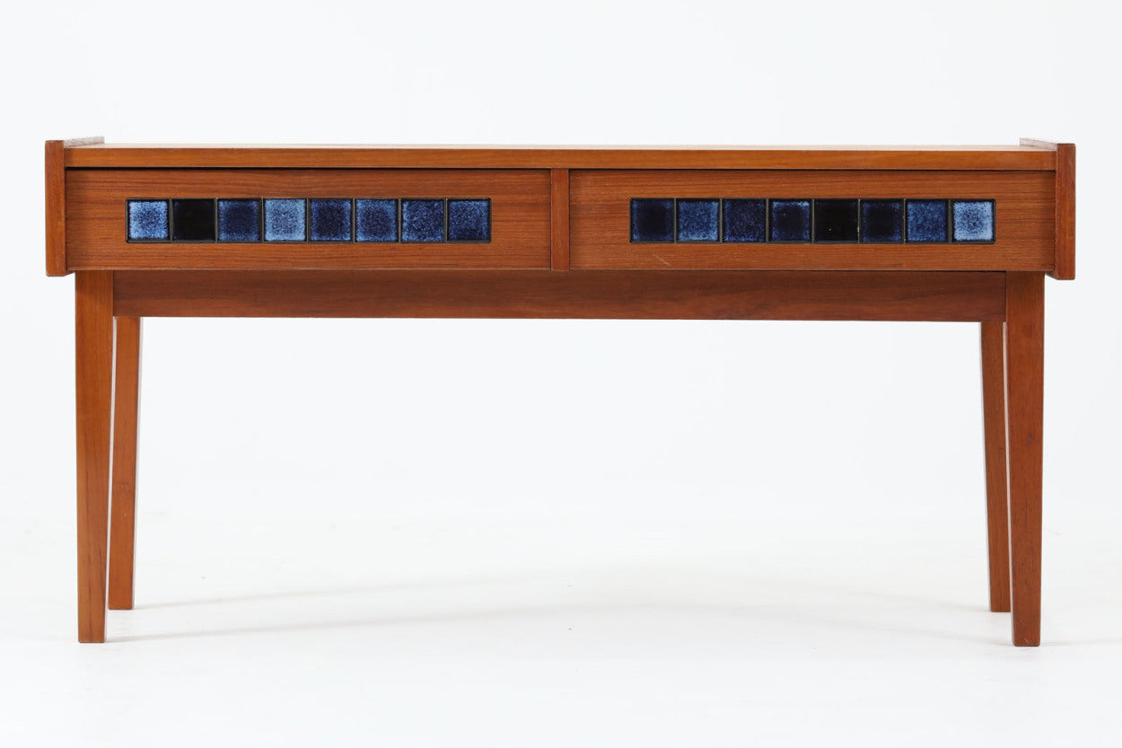 こちらは、北欧より買い付けたワイドチェストです。優れた品質のチーク材を本体に使用し、引き出し前板には鮮やかなブルーのタイルが施されており、デザインのアクセントとなっています。また、左右に取り付けられた細身のテーパー脚が、全体に洗練された印象を与えています。幅90cmのワイドサイズなので、ローボードやセンターテーブルとしてもお使いいただけます。