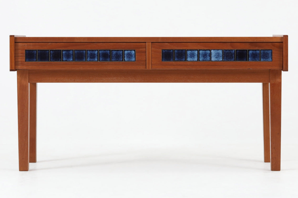 こちらは、北欧より買い付けたワイドチェストです。優れた品質のチーク材を本体に使用し、引き出し前板には鮮やかなブルーのタイルが施されており、デザインのアクセントとなっています。また、左右に取り付けられた細身のテーパー脚が、全体に洗練された印象を与えています。幅90cmのワイドサイズなので、ローボードやセンターテーブルとしてもお使いいただけます。