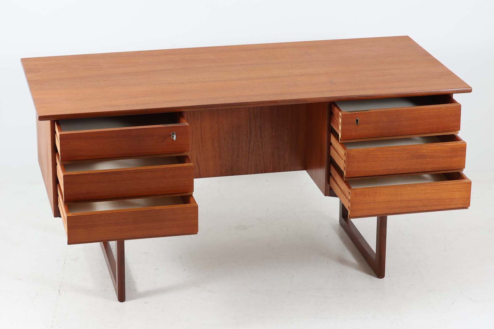 デンマークより買い付けた両袖デスクです。脚間の渡し木を脚先で繋げる事によりデザイン性の高い商品となっています。取手は削り出す事により作成されており本体フレーム内に納まりスッキリとした印象です。バックシェルフもあるためお部屋の真ん中に置いてもご使用いただけます。