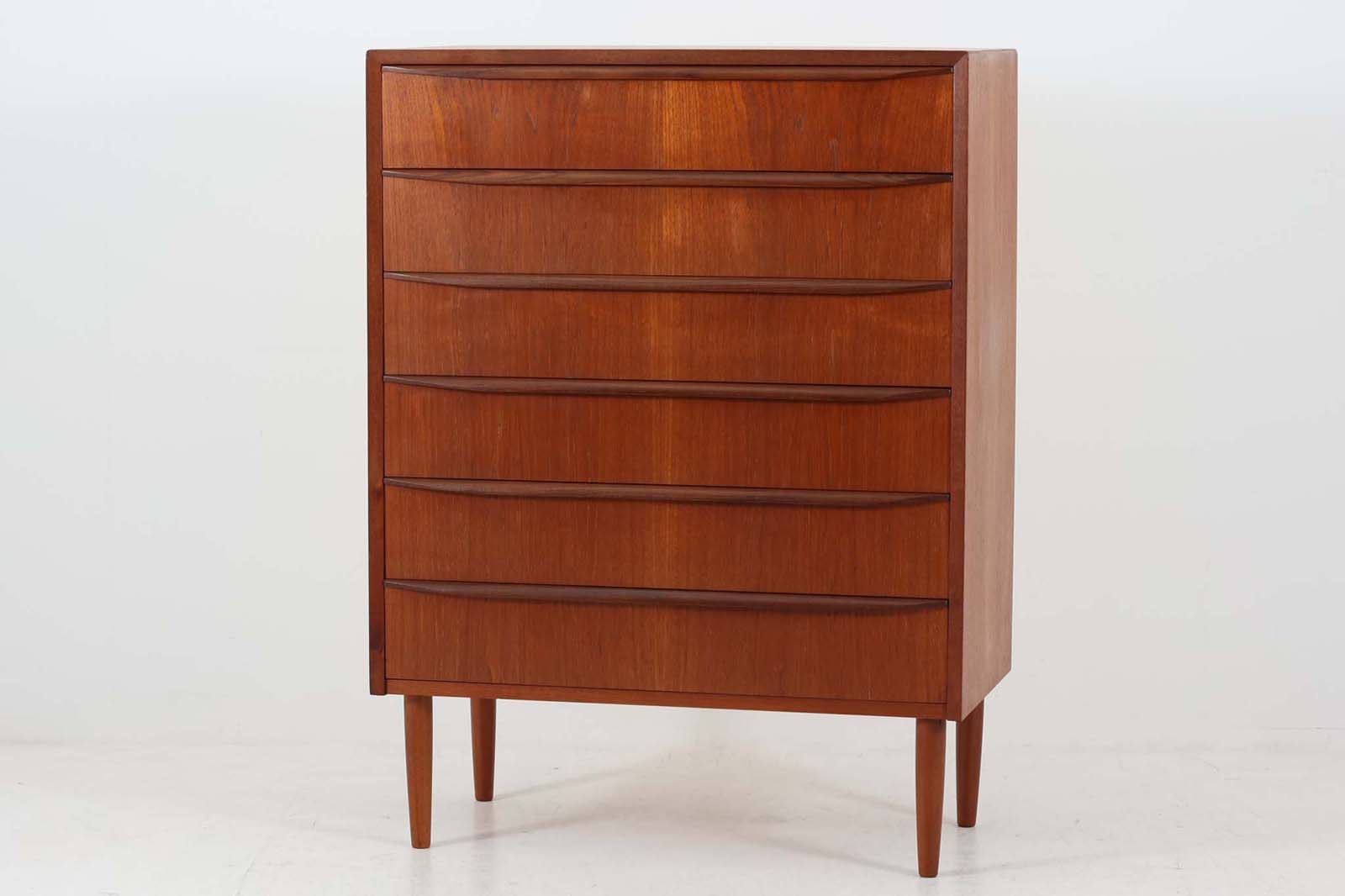 北欧より買い付けた6段チェストです。正面から見ると綺麗に揃ったチーク材の木目が素敵です。北欧家具らしいバータイプの取手です。