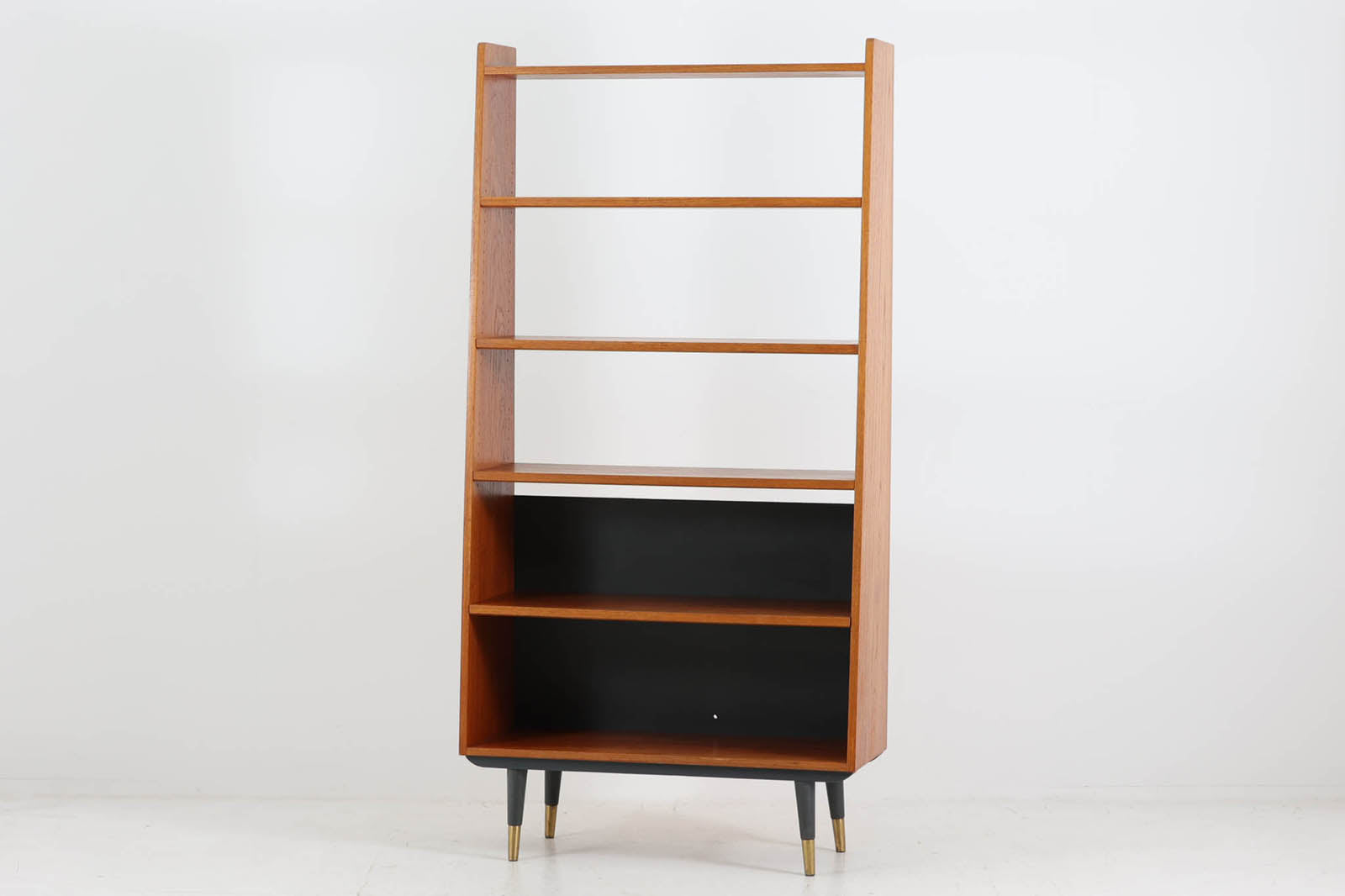 スウェーデンより買い付けたブックシェルフです。本体には良質なチーク材が使用されており、脚はブラックペイントと脚先には真鍮のキャップがはめ込まれています。上半分がオープンタイプになっている珍しいデザインで、空間を圧迫する事なくご使用いただけます。