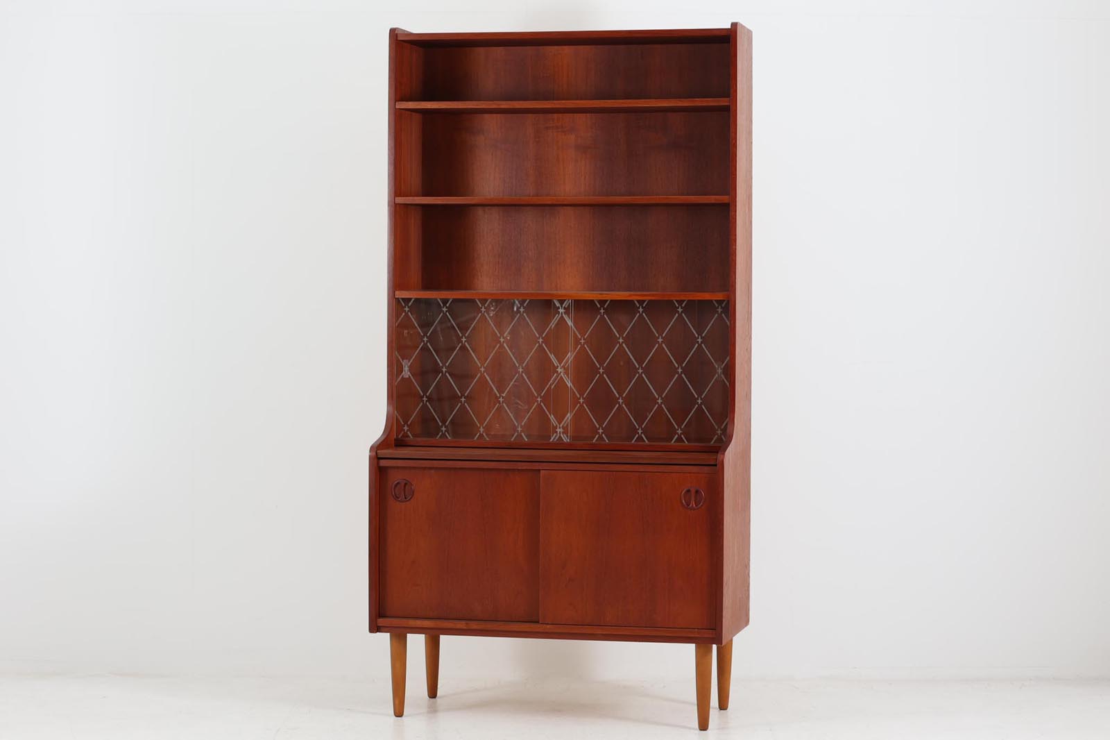 デンマーク製のディスプレイシェルフです。中央にガラス戸が使用された珍しいモデルです。本体には良質なチーク材が使用されています。