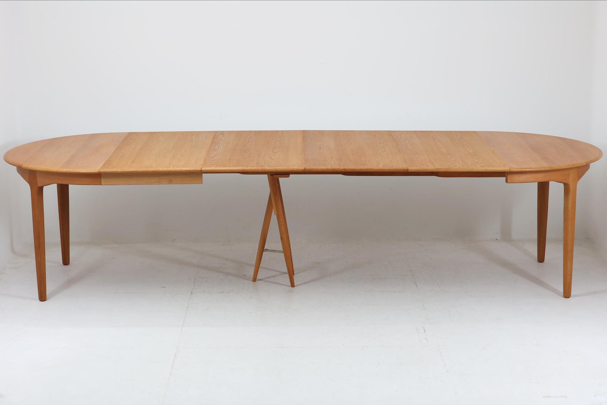 北欧より買い付けた、HenningKjaernulfによってデザインされた円形ダイニングテーブルです。天板を広げた際に中央のサポートの脚が開き、大人数での食卓を想定したデザインとなっています。拡張板は4枚付属し、用途に併せて幅の調整が可能です。良質なオーク材が使用されており、デンマークの名工SoroStolefabrikの熟練の職人によって作成された希少なテーブルです。