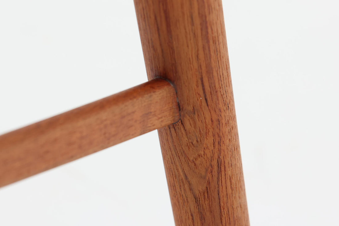 Kai Kristiansenのネイルチェアは、デンマークの名工によって手作りされ、その独創的なデザインと高品質なクラフトマンシップで称賛されています。洗練された背もたれの曲線と美しい木製のフレーム、そして小さなアームが特徴で、快適な座り心地を提供します。背もたれにファブリックが張られた珍しいタイプです。
