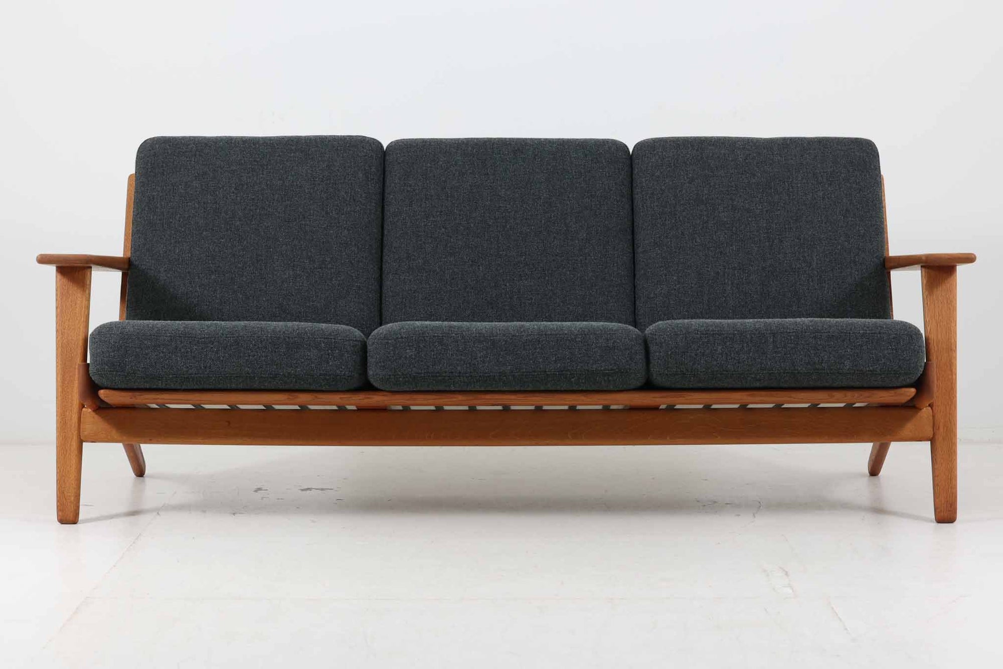 北欧家具を代表するソファ『GE290』です。現在リプロダクト品が販売されていますが、こちらは本物です。元々はベッド会社であるGETAmA社ならではのコイルスプリングが内包されたクッションの座り心地は、弾力があり心地良く、読書や映画などのリラックスタイムに最適です。立ち上がる際も適度なはね返りがあるので、動く時に億劫になる事はありません。HansJ.Wegnerならではの時代を超えた素晴らしいデザインです。横や背面から見るとまた違った表情を感じて頂けると思います。