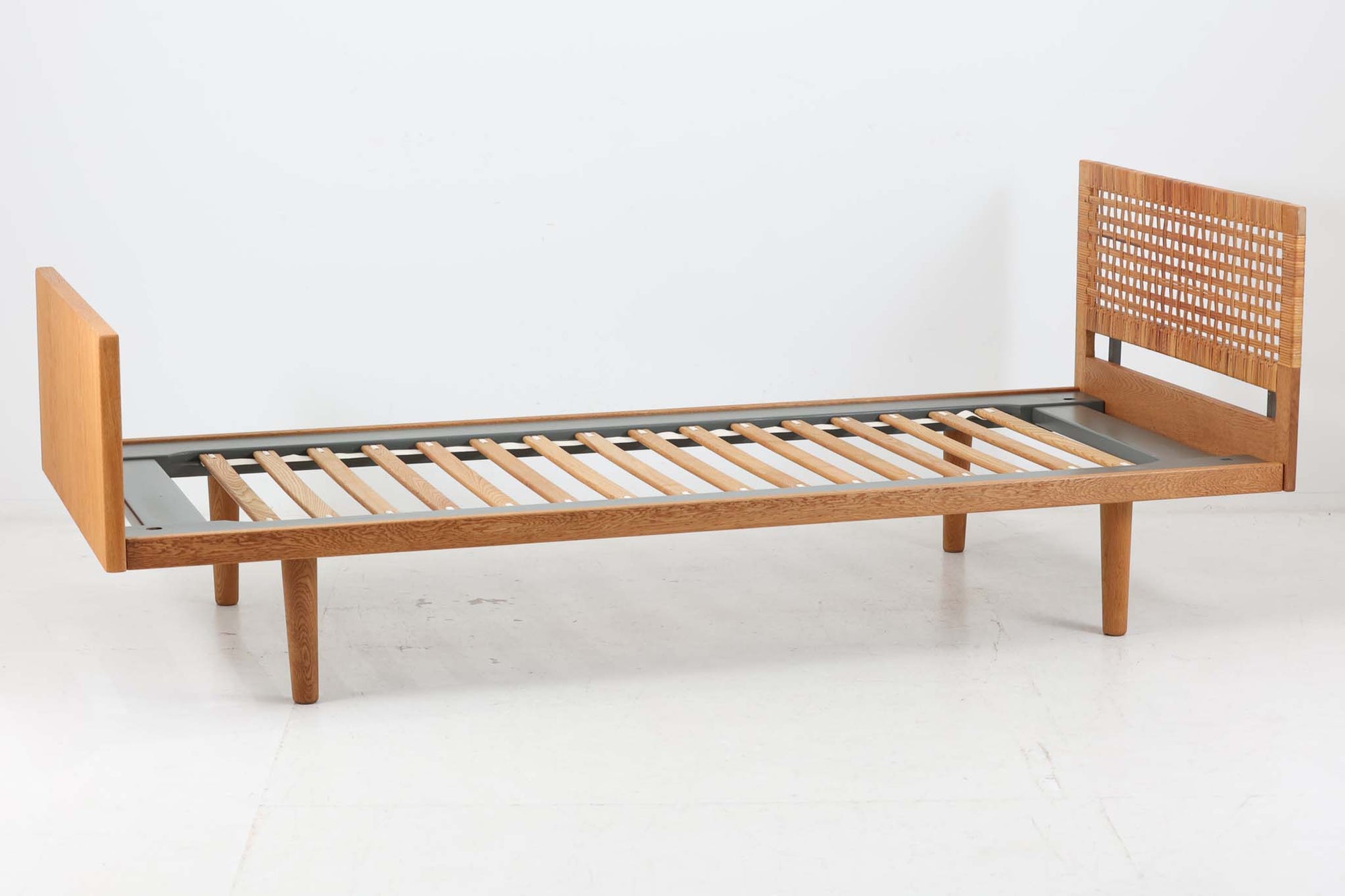 北欧より買い付けたHansJ.WegnerによるGETAmA社製ベッドフレームです。小ぶりなタイプですっきりとしたデザインです。本体には良質なオーク材が使用されており、当時流行した籐が本体に組み込まれています。マットレスは付属しません。マットサイズは最大「幅80×200cm」です。セミシングルサイズのマットレスをご用意ください。