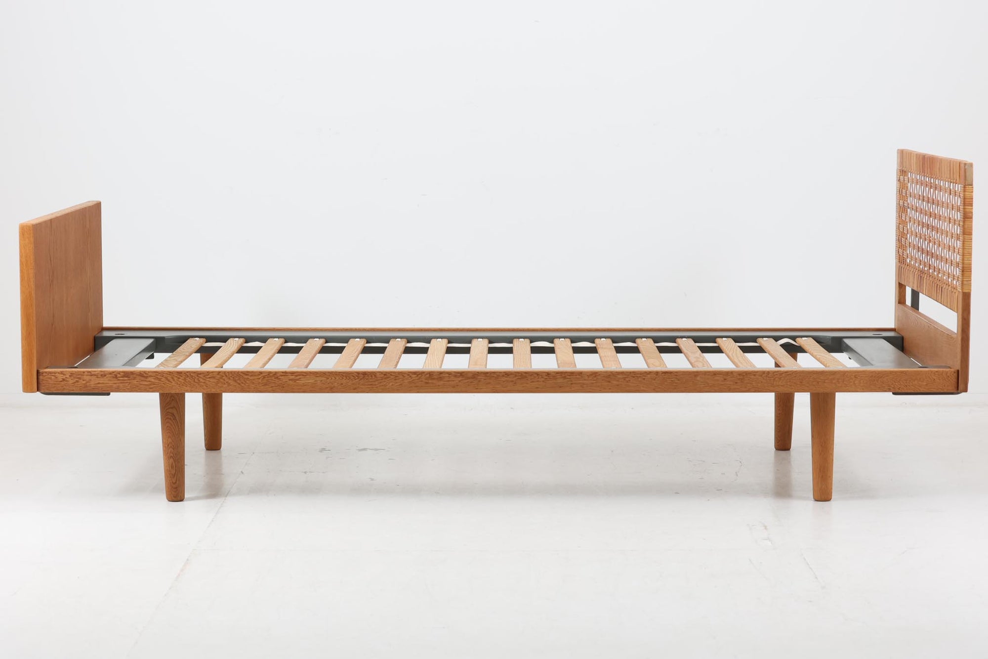北欧より買い付けたHansJ.WegnerによるGETAmA社製ベッドフレームです。小ぶりなタイプですっきりとしたデザインです。本体には良質なオーク材が使用されており、当時流行した籐が本体に組み込まれています。マットレスは付属しません。マットサイズは最大「幅80×200cm」です。セミシングルサイズのマットレスをご用意ください。
