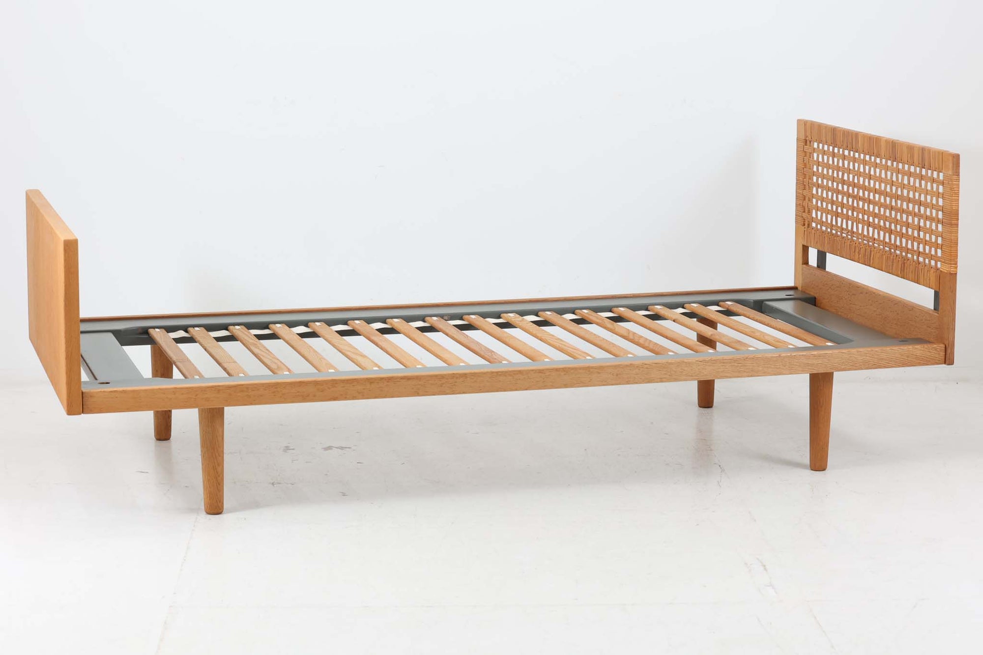 北欧より買い付けたHansJ.WegnerによるGETAmA社製ベッドフレームです。小ぶりなタイプですっきりとしたデザインです。本体には良質なオーク材が使用されており、当時流行した籐が本体に組み込まれています。マットレスは付属しません。マットサイズは最大「幅80×200cm」です。セミシングルサイズのマットレスをご用意ください。