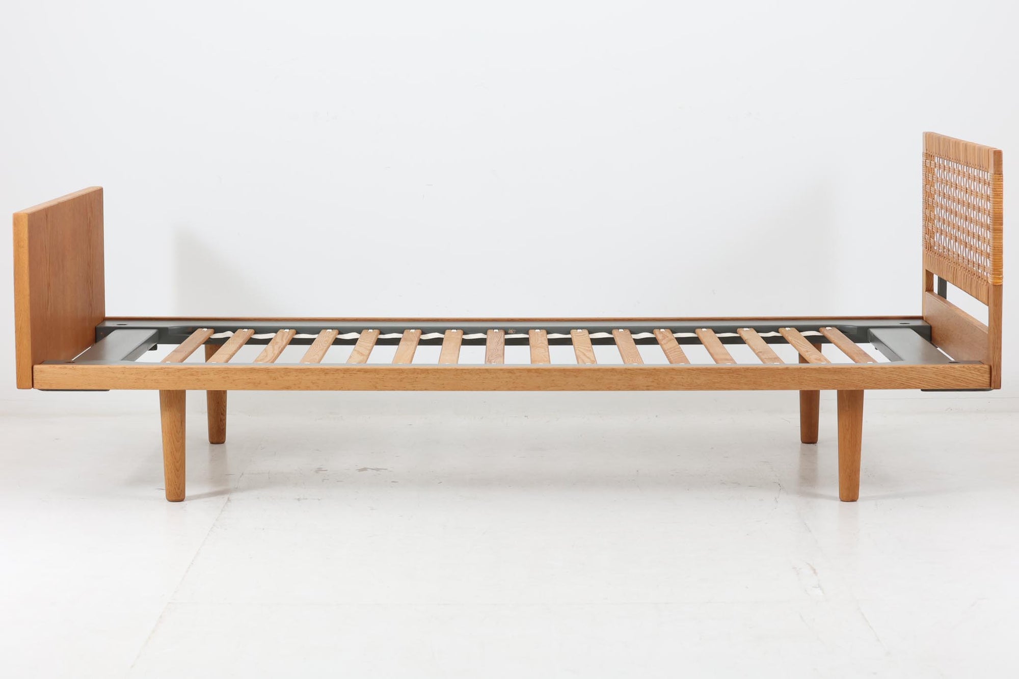 北欧より買い付けたHansJ.WegnerによるGETAmA社製ベッドフレームです。小ぶりなタイプですっきりとしたデザインです。本体には良質なオーク材が使用されており、当時流行した籐が本体に組み込まれています。マットレスは付属しません。マットサイズは最大「幅80×200cm」です。セミシングルサイズのマットレスをご用意ください。