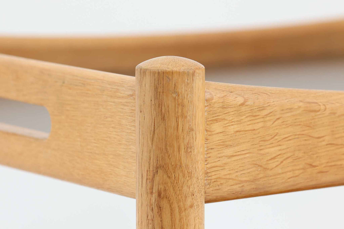 北欧で買い付けた「Hans J. Wegner」によるデザインの"AT45"ワゴンは、木製のフレームと繊細なディテール仕上げが、デンマークデザインの優雅さを引き立て、どんなインテリアにも調和します。使い勝手も抜群で、スムーズに移動できるキャスターが取り付けられており、必要な時に軽々と移動させることができます。天板と棚には水物も使用可能なように、ブラウンのラミネートが施されており、オーク材とのコントラストが美しい色調を生み出しています。このアイテムはデンマークのセレクトショップCentral moblerで販売されていたものです。