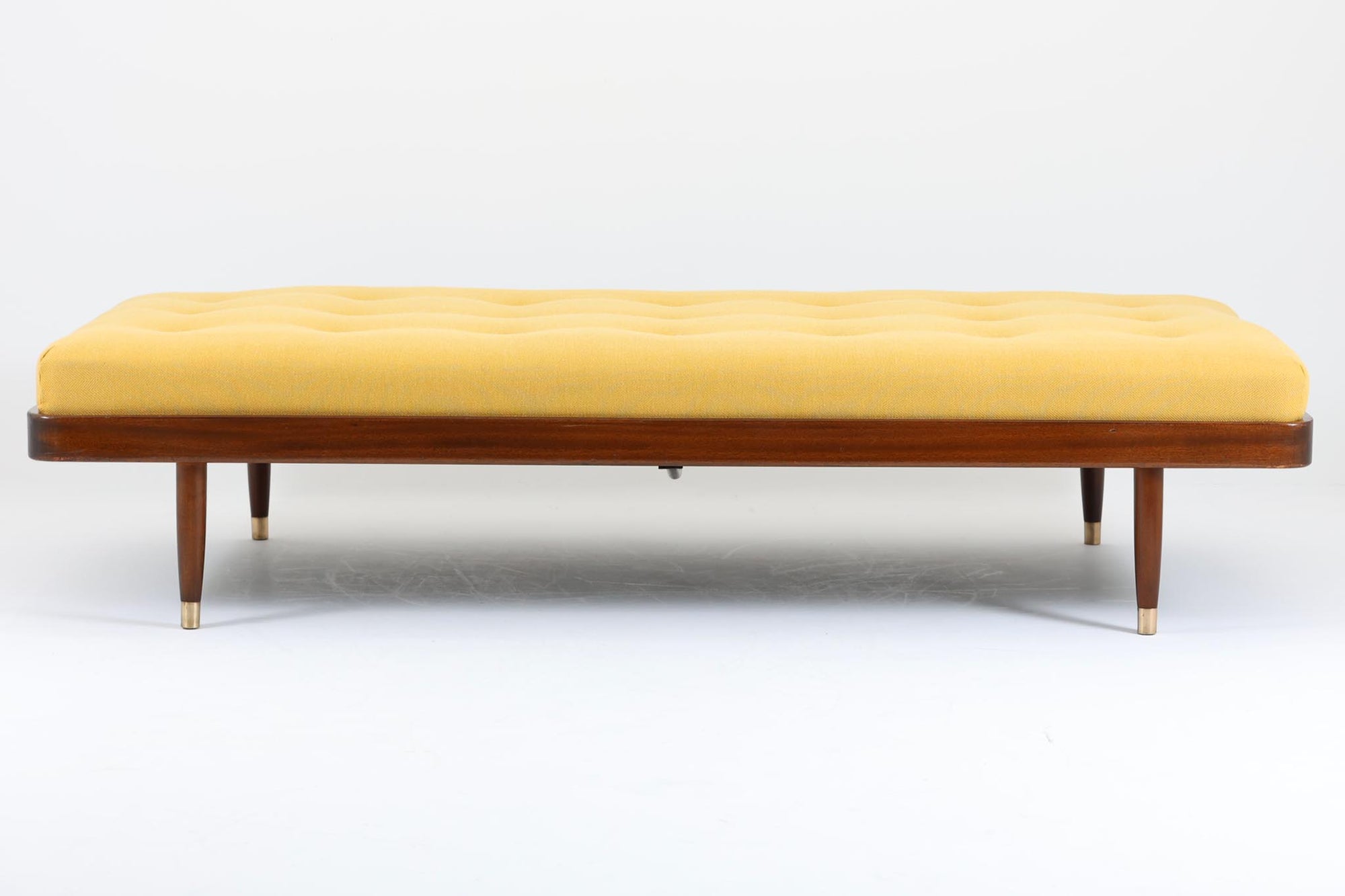 北欧ビンテージ家具ならではの特徴的なアイテムです。ベンチとしても、ソファとしても、そしてベッドとしても利用可能なため、空間の効率的な活用が可能です。クッションにはスプリングが内蔵されており、座り心地も快適です。クッションに施されたボタンダウンが、モダンな雰囲気を演出し、明るいイエローの色調がお部屋全体に明るさをもたらします。脚先には真鍮キャップが付いており、上品な印象を与えてくれます。