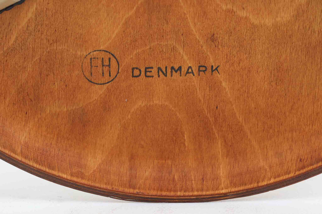 1954年、デンマークのデザイナー、Arne Jacobsen（アルネ・ヤコブセン）によって発表された3本脚のスツール、「DOT（ドット）」。このスツールは、ヤコブセンが手がけた「ルードブレ市庁舎」のロビーで待合席として使用されていました。1970年には4本脚のバージョンも登場しましたが、3本脚のモデルは同年に廃盤となり、現在はビンテージ品のみで入手可能です。オフィスや自宅での日常的な使用はもちろん、予備の椅子としても便利なこのスツールは、シンプルなデザインが魅力です。座面の中央がわずかにくぼんでおり、座った際にフィット感を生み出します。シンプルながらもヤコブセンのこだわりが感じられ、また、単なるスツールとしてだけでなく、ソファの横に置いて本や小物を置くサイドテーブルとしても活用できます。座面裏には薄っすらとFritz Hansen社の刻印がございます。