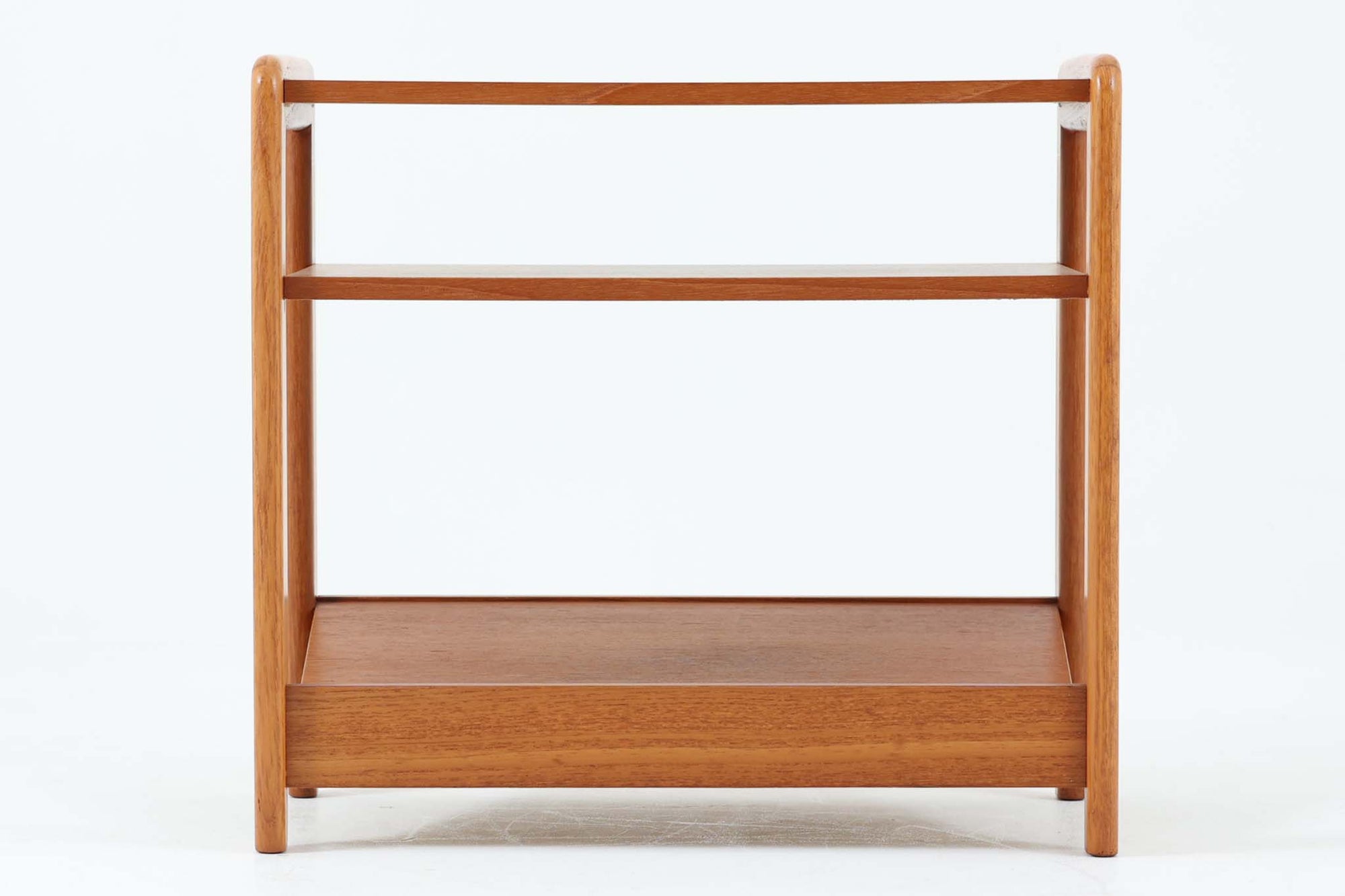 北欧で使用されていた、ドイツ製のサイドテーブルをご紹介いたします。このテーブルは、北欧家具を意識したデザインでありながら、独自の時代の流れを感じさせる魅力を持っています。上質なチーク材が使用されており綺麗な木目です。本体には傾斜のついた棚板も付いており、マガジンラックとして魅せる収納が出来そうです。