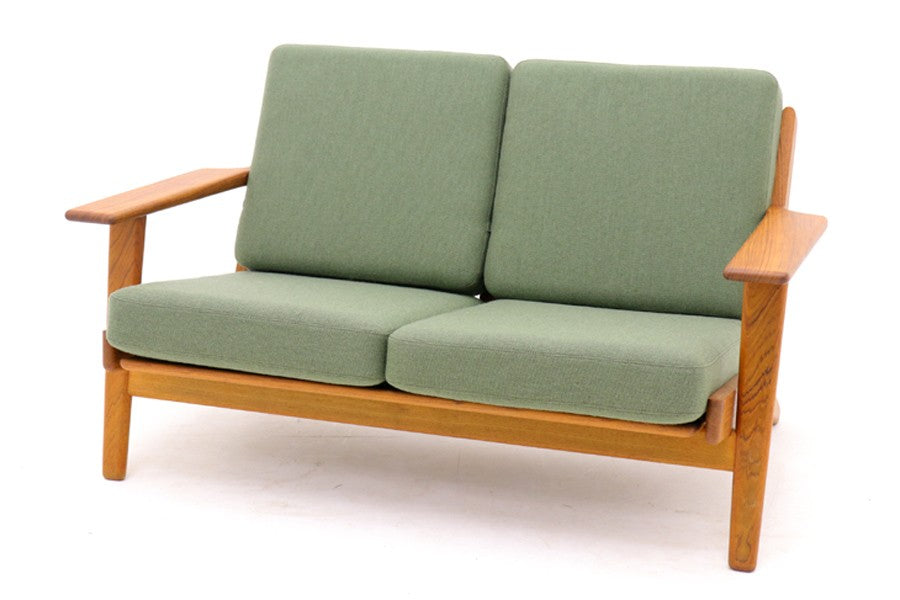 北欧家具を代表するソファ『GE290』です。現在リプロダクト品が販売されていますが、こちらは本物です。元々はベッド会社であるGETAmA社ならではのコイルスプリングが内包されたクッションの座り心地は、弾力があり心地良く、読書や映画などのリラックスタイムに最適です。立ち上がる際も適度なはね返りがあるので、動く時に億劫になる事はありません。HansJ.Wegnerならではの時代を超えた素晴らしいデザインです。横や背面から見るとまた違った表情を感じて頂けると思います。お部屋にドンと置いてその存在感をお楽しみ下さい。こちらは現行品では手に入れる事が出来ない、チーク材の希少なモデルです。