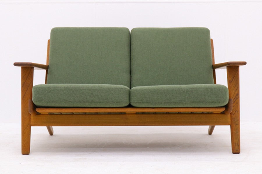 北欧家具を代表するソファ『GE290』です。現在リプロダクト品が販売されていますが、こちらは本物です。元々はベッド会社であるGETAmA社ならではのコイルスプリングが内包されたクッションの座り心地は、弾力があり心地良く、読書や映画などのリラックスタイムに最適です。立ち上がる際も適度なはね返りがあるので、動く時に億劫になる事はありません。HansJ.Wegnerならではの時代を超えた素晴らしいデザインです。横や背面から見るとまた違った表情を感じて頂けると思います。お部屋にドンと置いてその存在感をお楽しみ下さい。こちらは現行品では手に入れる事が出来ない、チーク材の希少なモデルです。