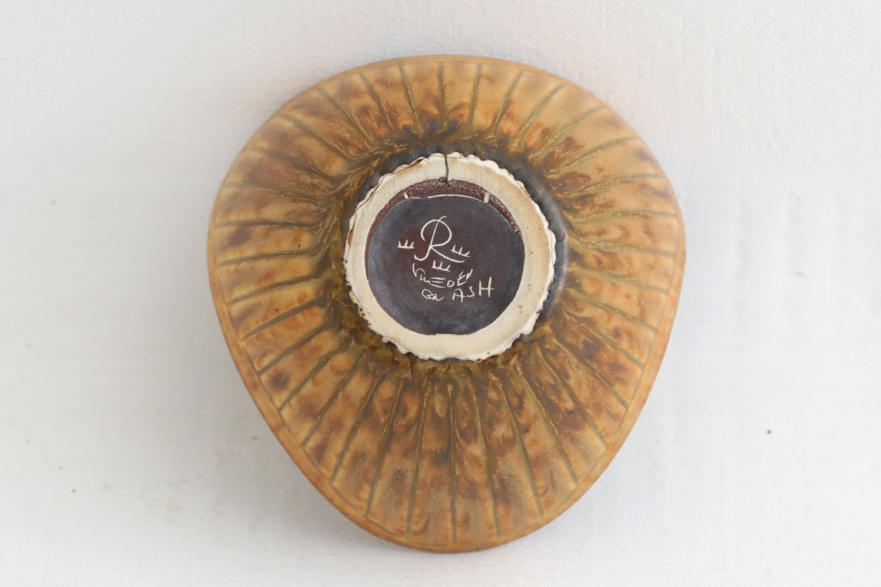 フィンランド人で彫刻家の父と、デンマーク人で陶芸家の母の元に育つGunnarNylundはデンマークで建築を学んだ後、Bing&amp;amp;Grondahl窯、スウェーデンRorstrand窯に就業し、多くの作品を生み出しています。彼の作品は独特な流線型と釉薬が特徴で世界中で重宝されています。