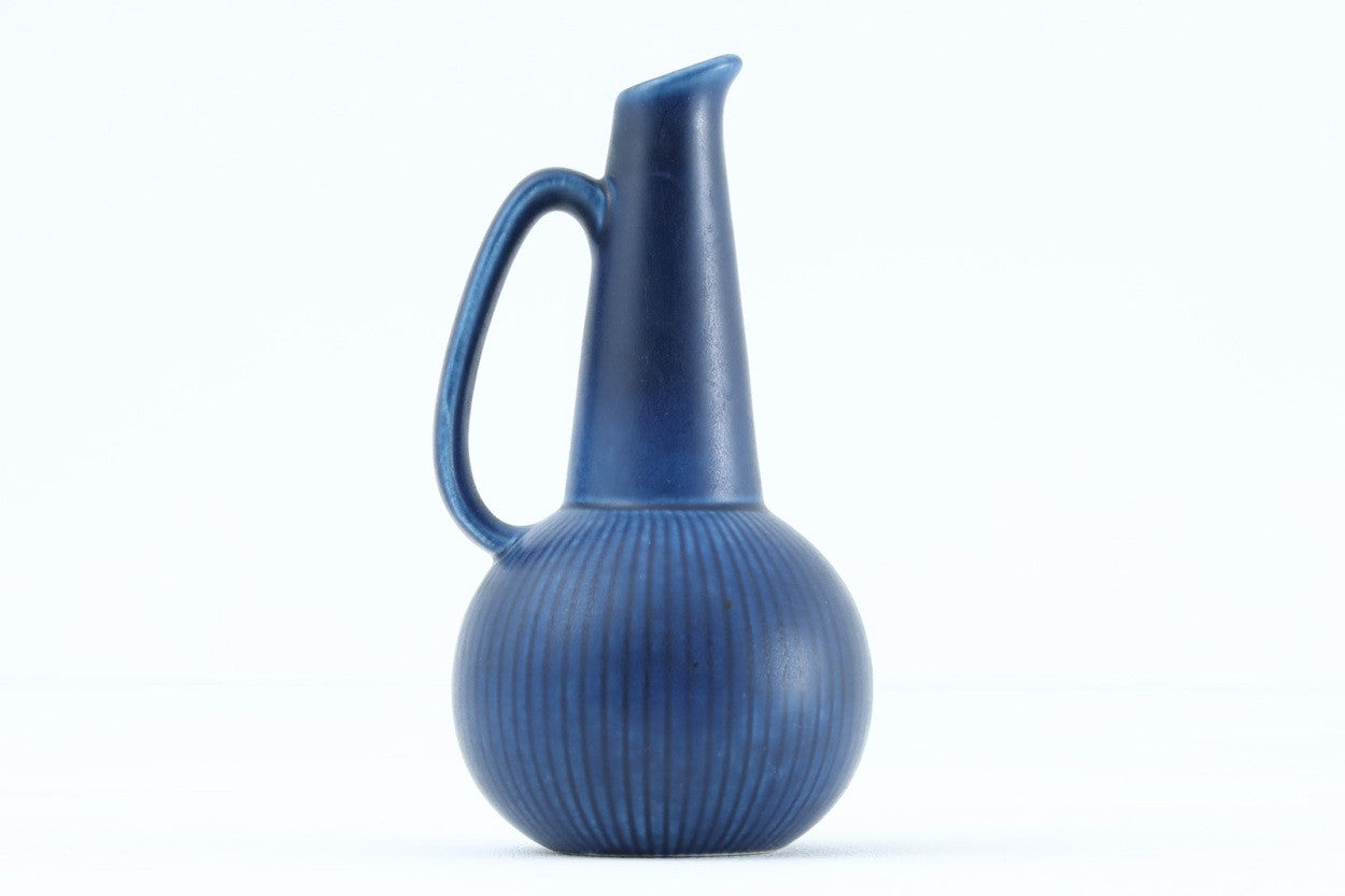 フィンランド人で彫刻家の父と、デンマーク人で陶芸家の母の元に育つGunnarNylundはデンマークで建築を学んだ後、Bing&amp;amp;Grondahl窯、スウェーデンRorstrand窯に就業し、多くの作品を生み出しています。彼の作品は独特な流線型と釉薬が特徴で世界中で重宝されています。