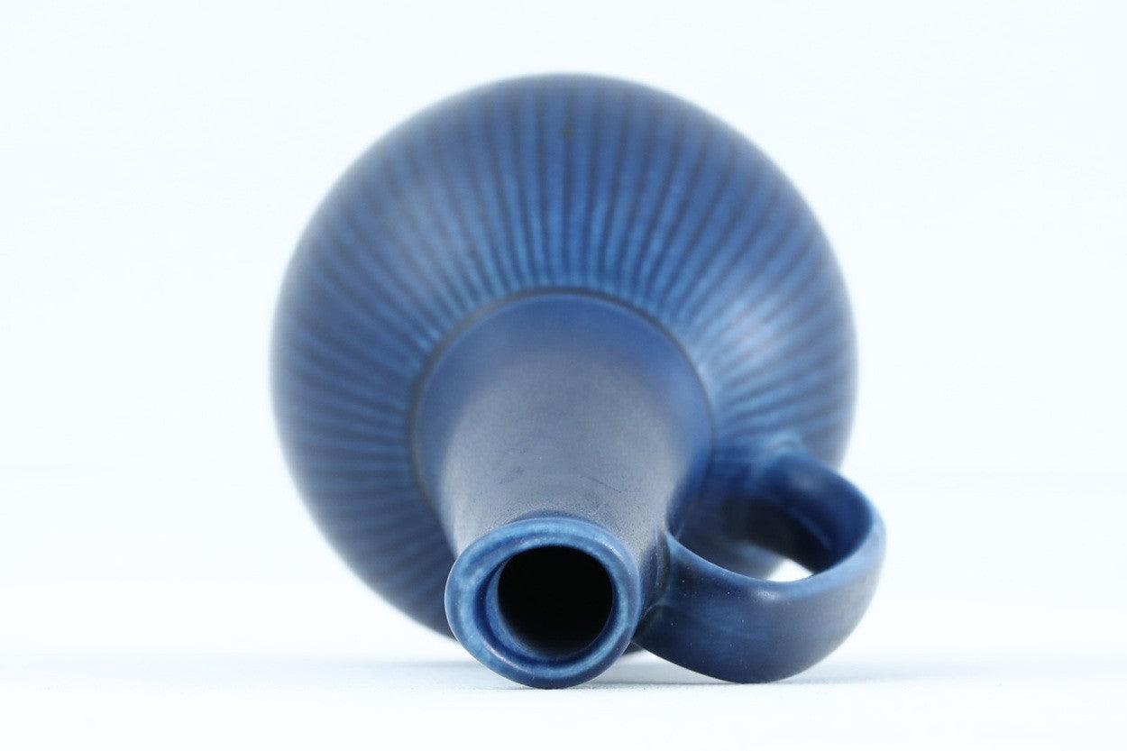 フィンランド人で彫刻家の父と、デンマーク人で陶芸家の母の元に育つGunnarNylundはデンマークで建築を学んだ後、Bing&amp;amp;Grondahl窯、スウェーデンRorstrand窯に就業し、多くの作品を生み出しています。彼の作品は独特な流線型と釉薬が特徴で世界中で重宝されています。