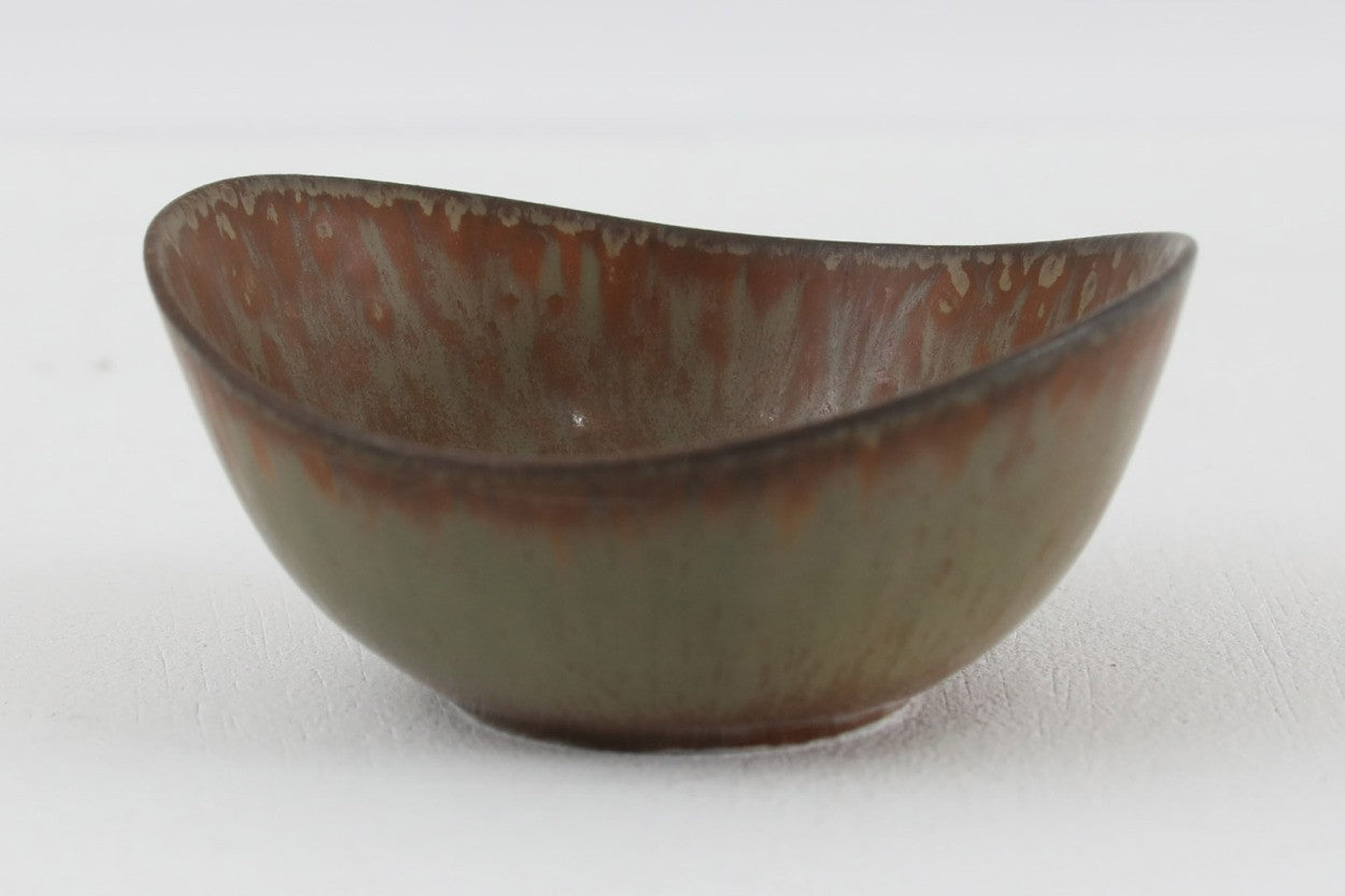 フィンランド人で彫刻家の父と、デンマーク人で陶芸家の母の元に育つGunnarNylundはデンマークで建築を学んだ後、Bing&amp;Grondahl窯、スウェーデンRorstrand窯に就業し、多くの作品を生み出しています。彼の作品は独特な流線型と釉薬が特徴で世界中で重宝されています。AROボウルは彼の最も代表的な作品で、その緩やかな美しいカーブが特徴です。また、さまざまな表情をみせる釉薬がコレクターにも人気がある理由です。