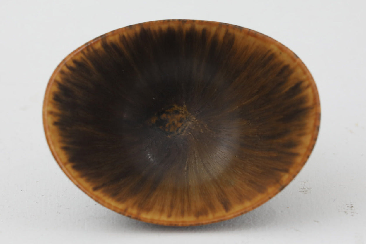 フィンランド人で彫刻家の父と、デンマーク人で陶芸家の母の元に育つGunnarNylundはデンマークで建築を学んだ後、Bing&amp;amp;Grondahl窯、スウェーデンRorstrand窯に就業し、多くの作品を生み出しています。彼の作品は独特な流線型と釉薬が特徴で世界中で重宝されています。AROボウルは彼の最も代表的な作品で、その緩やかな美しいカーブが特徴です。また、さまざまな表情をみせる釉薬がコレクターにも人気がある理由です。