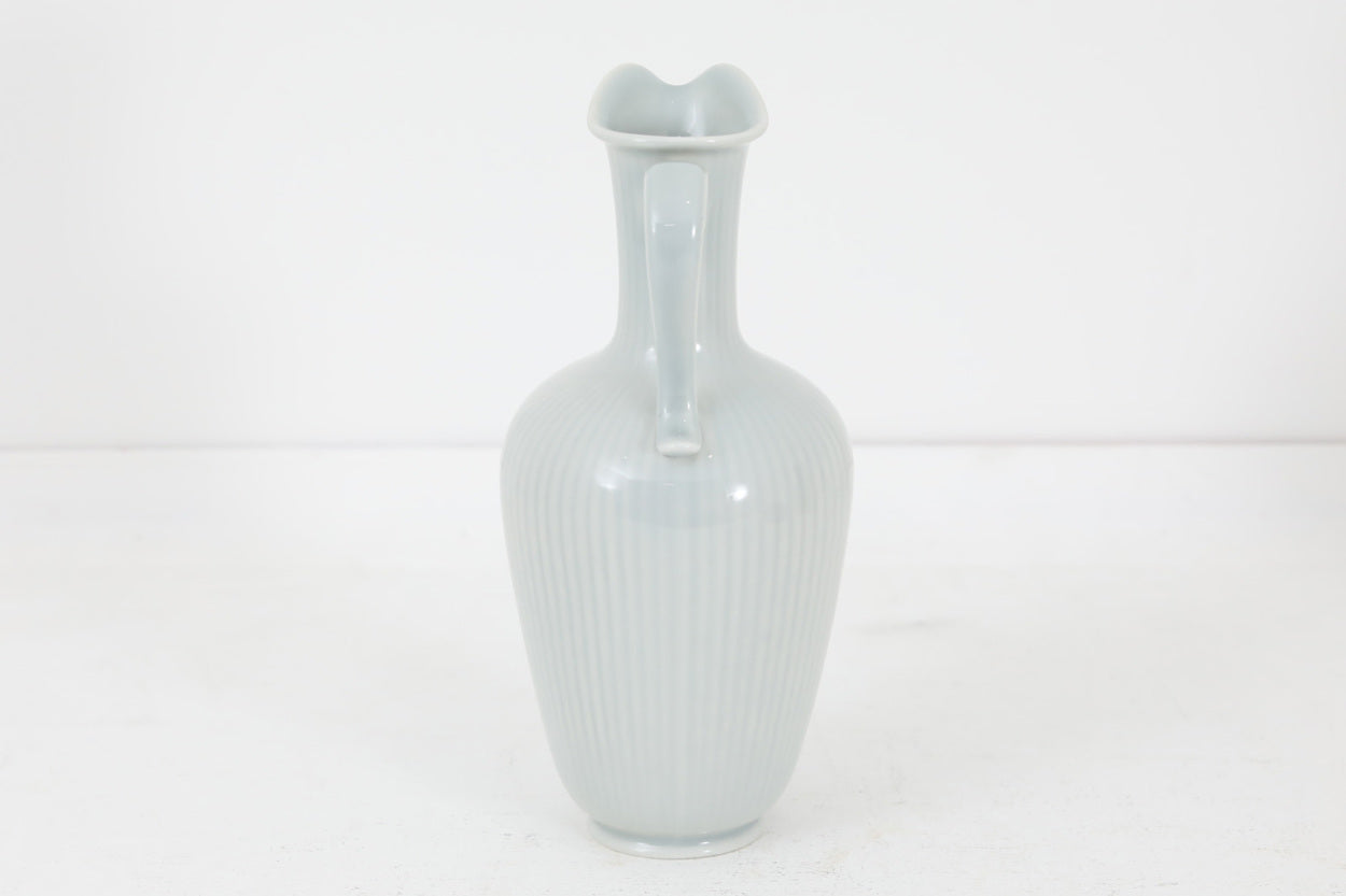 フィンランド人で彫刻家の父と、デンマーク人で陶芸家の母の元に育つGunnarNylundはデンマークで建築を学んだ後、Bing&amp;Grondahl窯、スウェーデンRorstrand窯に就業し、多くの作品を生み出しています。彼の作品は独特な流線型と釉薬が特徴で世界中で重宝されています。