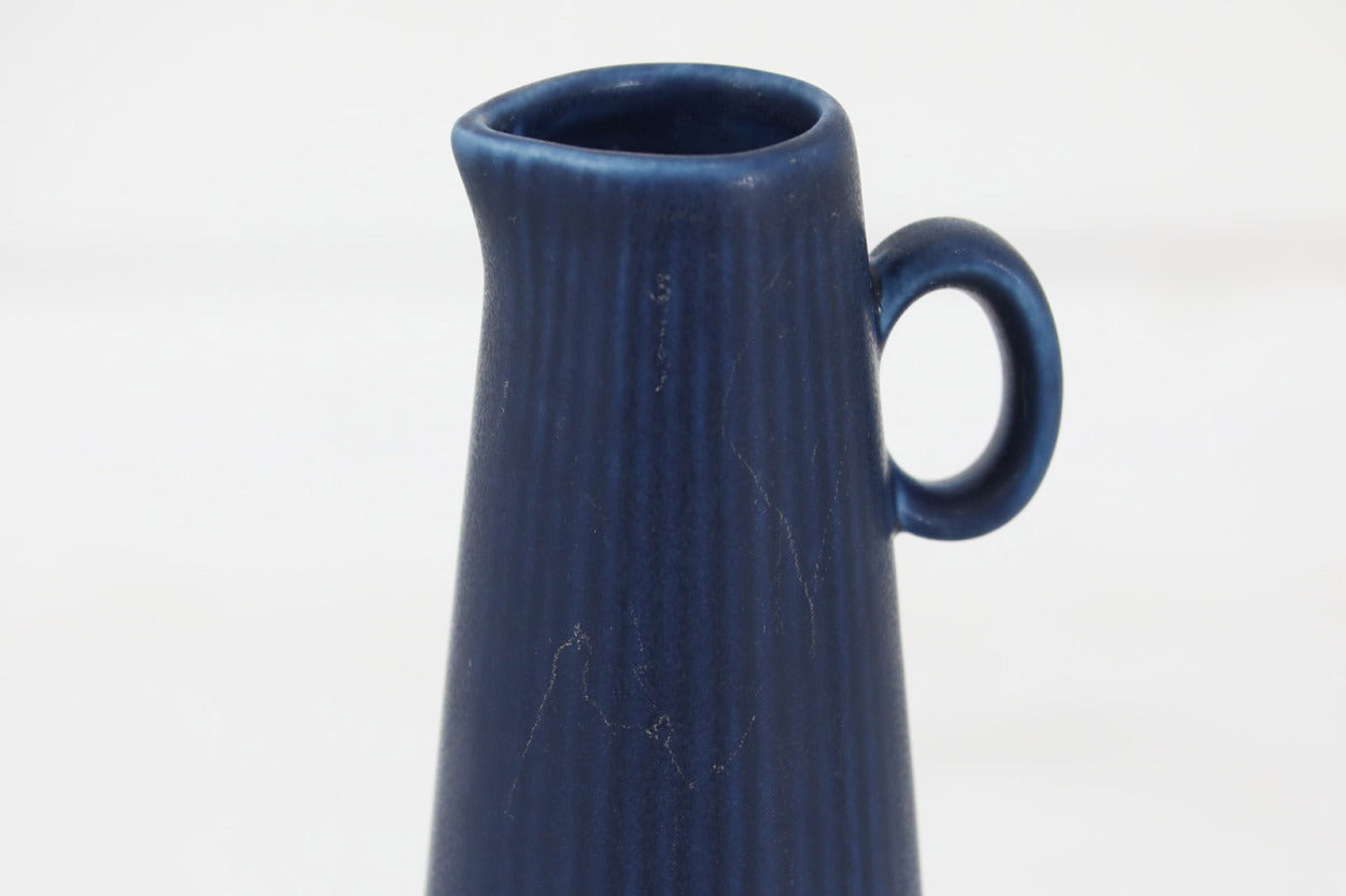 フィンランド人で彫刻家の父と、デンマーク人で陶芸家の母の元に育つGunnarNylundはデンマークで建築を学んだ後、Bing&amp;amp;Grondahl窯、スウェーデンRorstrand窯に就業し、多くの作品を生み出しています。彼の作品は独特な流線型と釉薬が特徴で世界中で重宝されています。