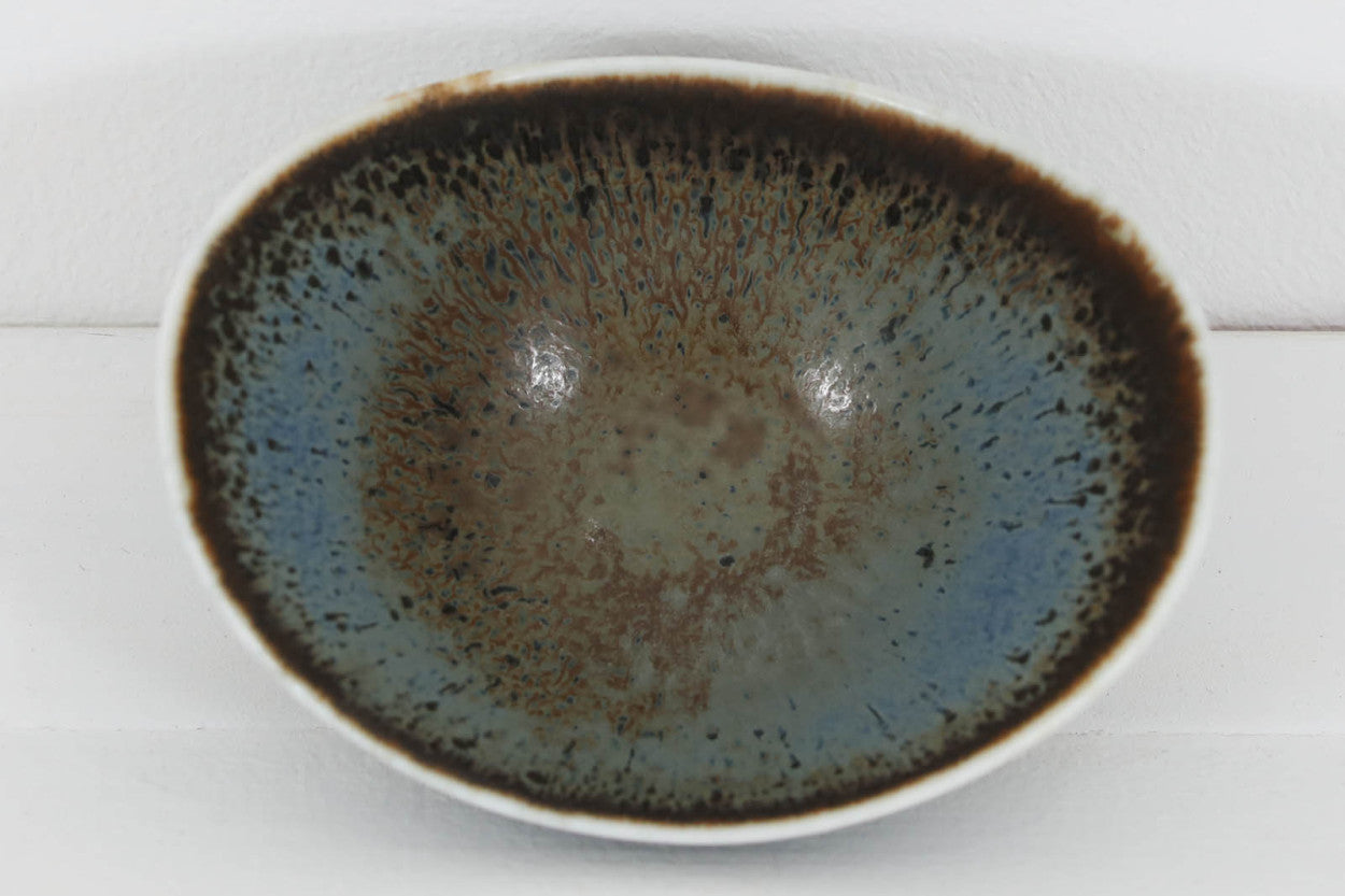 フィンランド人で彫刻家の父と、デンマーク人で陶芸家の母の元に育つGunnarNylundはデンマークで建築を学んだ後、Bing&amp;Grondahl窯、スウェーデンRorstrand窯に就業し、多くの作品を生み出しています。彼の作品は独特な流線型と釉薬が特徴で世界中で重宝されています。AROボウルは彼の最も代表的な作品で、その緩やかな美しいカーブが特徴です。また、さまざまな表情をみせる釉薬がコレクターにも人気がある理由です。