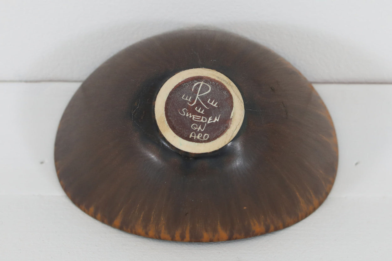 フィンランド人で彫刻家の父と、デンマーク人で陶芸家の母の元に育つGunnarNylundはデンマークで建築を学んだ後、Bing&amp;amp;Grondahl窯、スウェーデンRorstrand窯に就業し、多くの作品を生み出しています。彼の作品は独特な流線型と釉薬が特徴で世界中で重宝されています。AROボウルは彼の最も代表的な作品で、その緩やかな美しいカーブが特徴です。また、さまざまな表情をみせる釉薬がコレクターにも人気がある理由です。