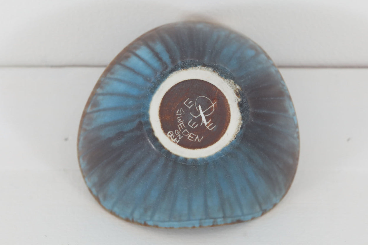 フィンランド人で彫刻家の父と、デンマーク人で陶芸家の母の元に育つGunnarNylundはデンマークで建築を学んだ後、Bing&amp;amp;Grondahl窯、スウェーデンRorstrand窯に就業し、多くの作品を生み出しています。彼の作品は独特な流線型と釉薬が特徴で世界中で重宝されています。