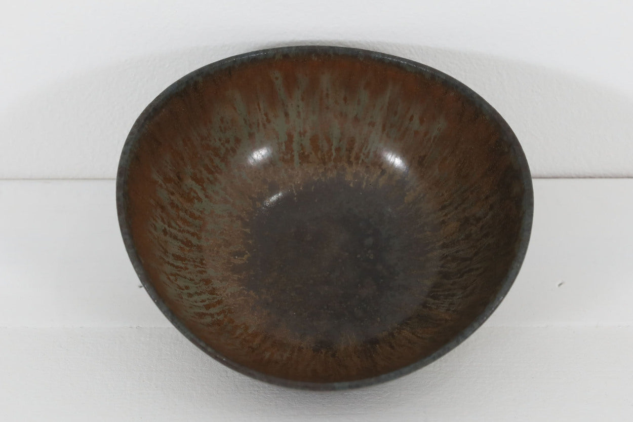 フィンランド人で彫刻家の父と、デンマーク人で陶芸家の母の元に育つGunnarNylundはデンマークで建築を学んだ後、Bing&amp;amp;Grondahl窯、スウェーデンRorstrand窯に就業し、多くの作品を生み出しています。彼の作品は独特な流線型と釉薬が特徴で世界中で重宝されています。AROボウルは彼の最も代表的な作品で、その緩やかな美しいカーブが特徴です。また、さまざまな表情をみせる釉薬がコレクターにも人気がある理由です。