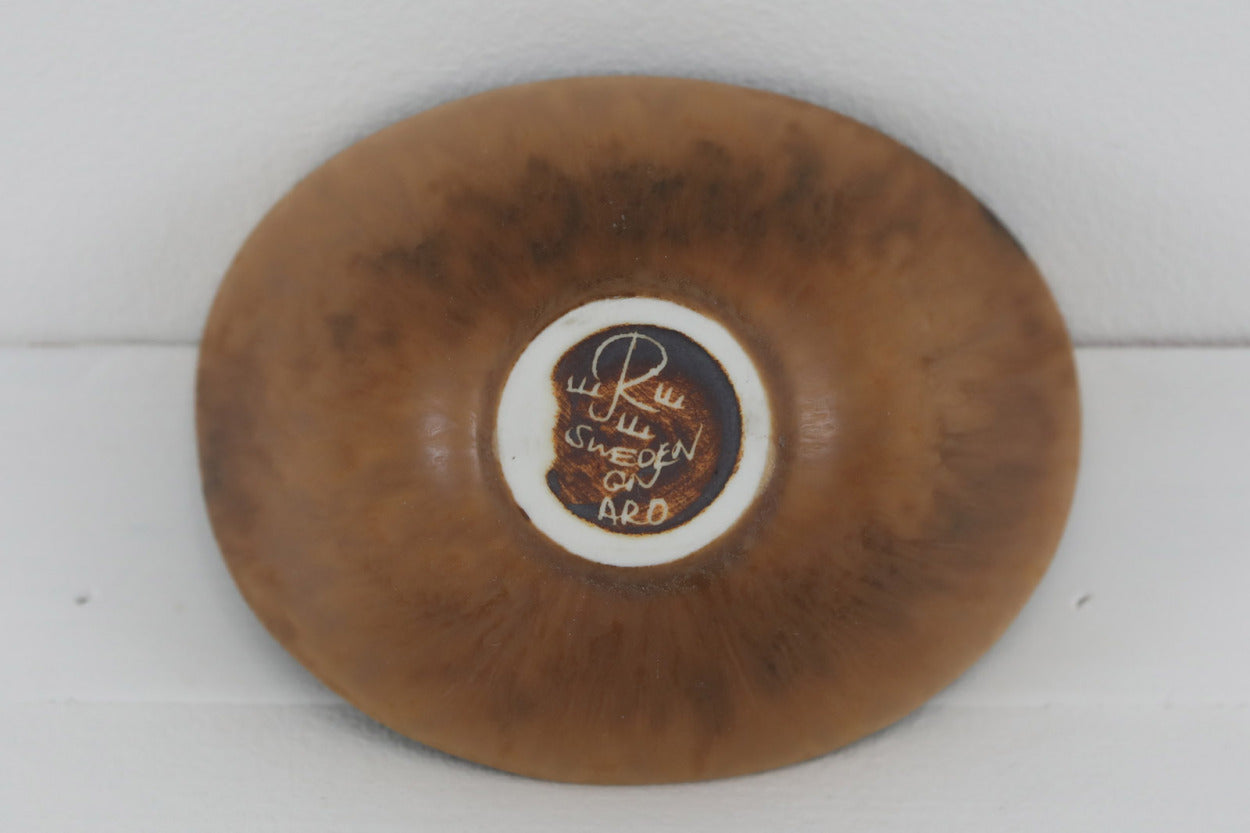 フィンランド人で彫刻家の父と、デンマーク人で陶芸家の母の元に育つGunnarNylundはデンマークで建築を学んだ後、Bing&amp;amp;Grondahl窯、スウェーデンRorstrand窯に就業し、多くの作品を生み出しています。彼の作品は独特な流線型と釉薬が特徴で世界中で重宝されています。AROボウルは彼の最も代表的な作品で、その緩やかな美しいカーブが特徴です。また、さまざまな表情をみせる釉薬がコレクターにも人気がある理由です。