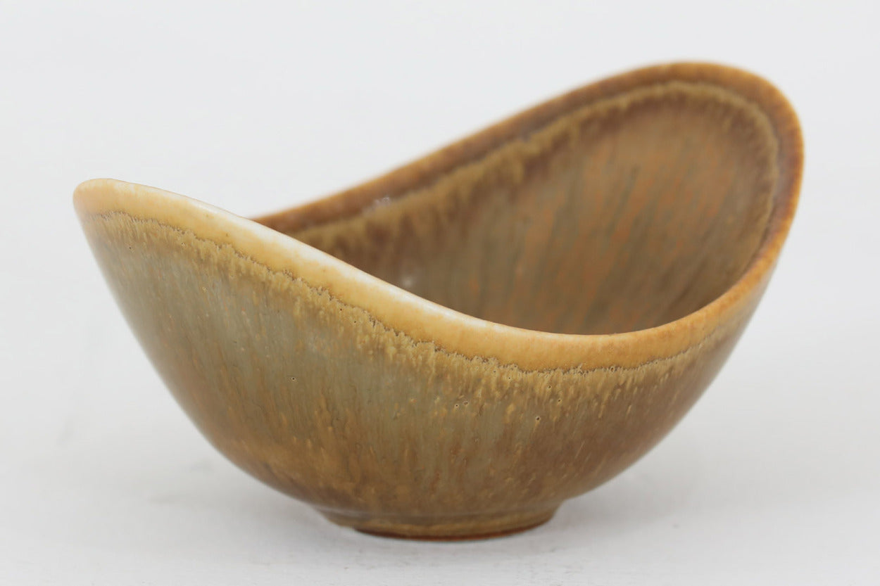 フィンランド人で彫刻家の父と、デンマーク人で陶芸家の母の元に育つGunnarNylundはデンマークで建築を学んだ後、Bing&amp;Grondahl窯、スウェーデンRorstrand窯に就業し、多くの作品を生み出しています。彼の作品は独特な流線型と釉薬が特徴で世界中で重宝されています。AROボウルは彼の最も代表的な作品で、その緩やかな美しいカーブが特徴です。また、さまざまな表情をみせる釉薬がコレクターにも人気がある理由です。