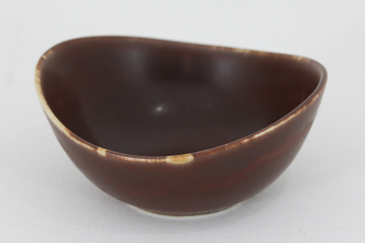 フィンランド人で彫刻家の父と、デンマーク人で陶芸家の母の元に育つGunnarNylundはデンマークで建築を学んだ後、Bing&amp;Grondahl窯、スウェーデンRorstrand窯に就業し、多くの作品を生み出しています。彼の作品は独特な流線型と釉薬が特徴で世界中で重宝されています。AROボウルは彼の最も代表的な作品で、その緩やかな美しいカーブが特徴です。また、さまざまな表情をみせる釉薬がコレクターにも人気がある理由です。