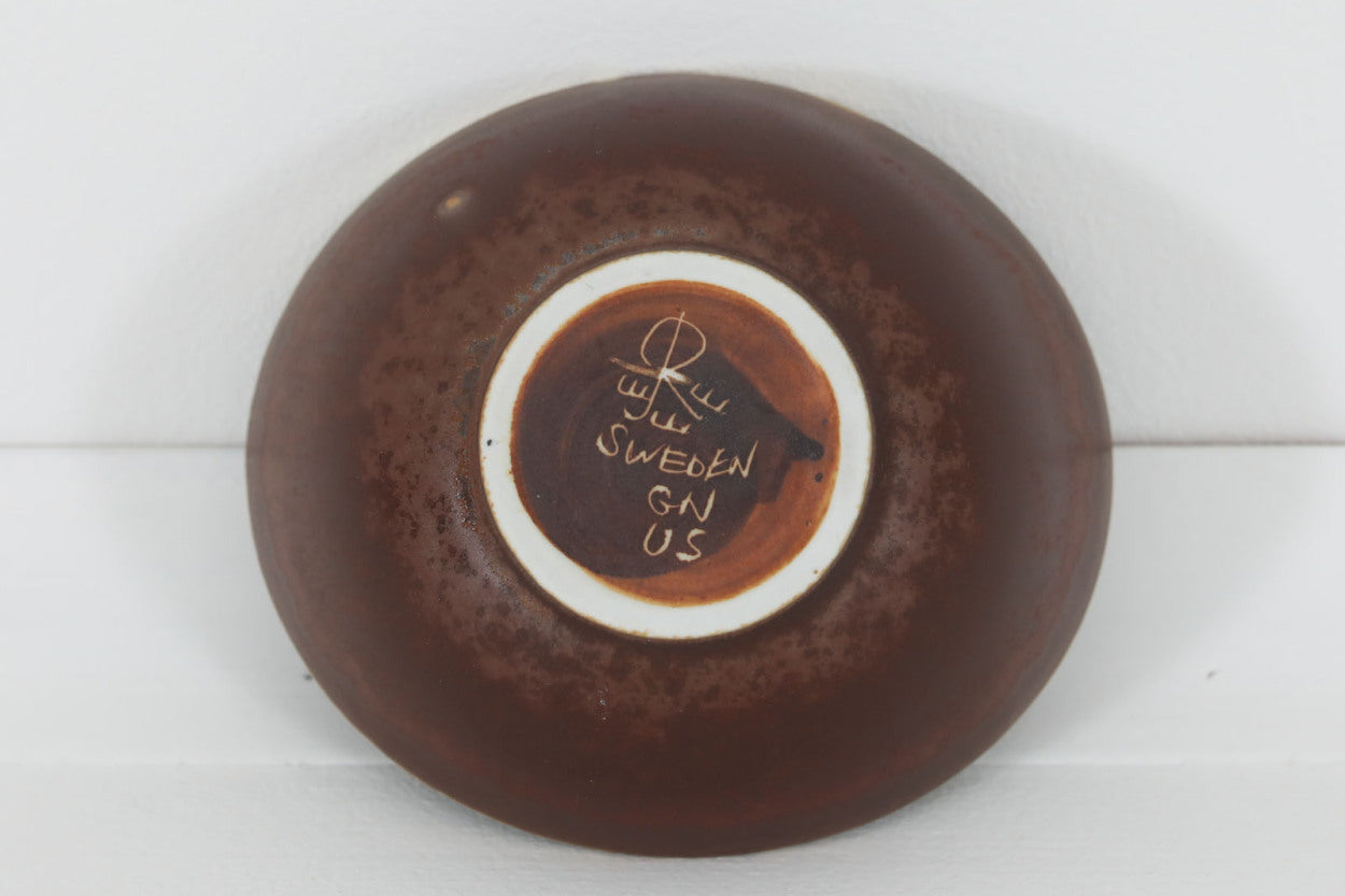 フィンランド人で彫刻家の父と、デンマーク人で陶芸家の母の元に育つGunnarNylundはデンマークで建築を学んだ後、Bing&amp;amp;Grondahl窯、スウェーデンRorstrand窯に就業し、多くの作品を生み出しています。彼の作品は独特な流線型と釉薬が特徴で世界中で重宝されています。AROボウルは彼の最も代表的な作品で、その緩やかな美しいカーブが特徴です。また、さまざまな表情をみせる釉薬がコレクターにも人気がある理由です。