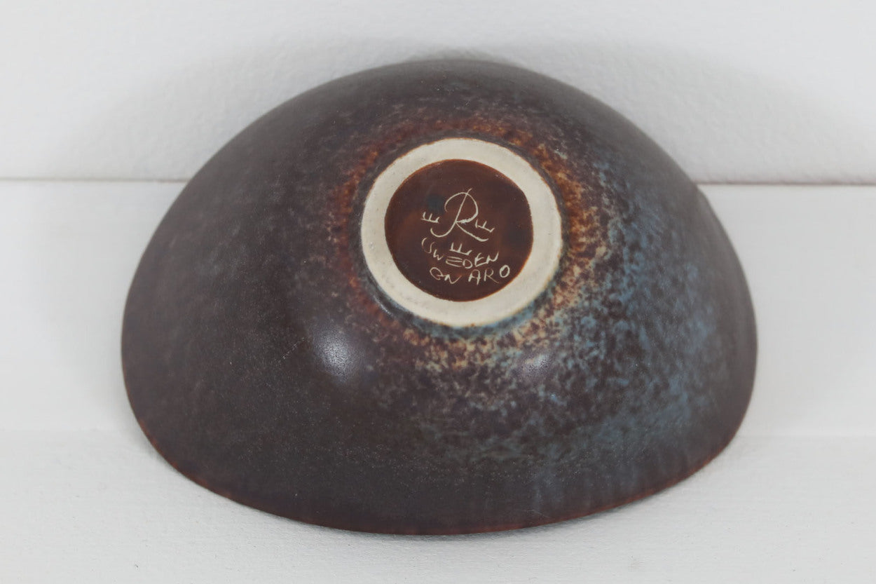 フィンランド人で彫刻家の父と、デンマーク人で陶芸家の母の元に育つGunnarNylundはデンマークで建築を学んだ後、Bing&amp;amp;Grondahl窯、スウェーデンRorstrand窯に就業し、多くの作品を生み出しています。彼の作品は独特な流線型と釉薬が特徴で世界中で重宝されています。AROボウルは彼の最も代表的な作品で、その緩やかな美しいカーブが特徴です。また、さまざまな表情をみせる釉薬がコレクターにも人気がある理由です。