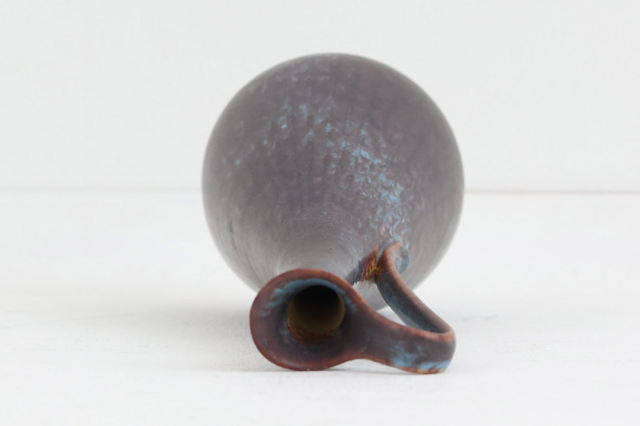 フィンランド人で彫刻家の父と、デンマーク人で陶芸家の母の元に育つGunnarNylundはデンマークで建築を学んだ後、Bing&amp;amp;Grondahl窯、スウェーデンRorstrand窯に就業し、多くの作品を生み出しています。彼の作品は独特な流線型と釉薬が特徴で世界中で重宝されています。