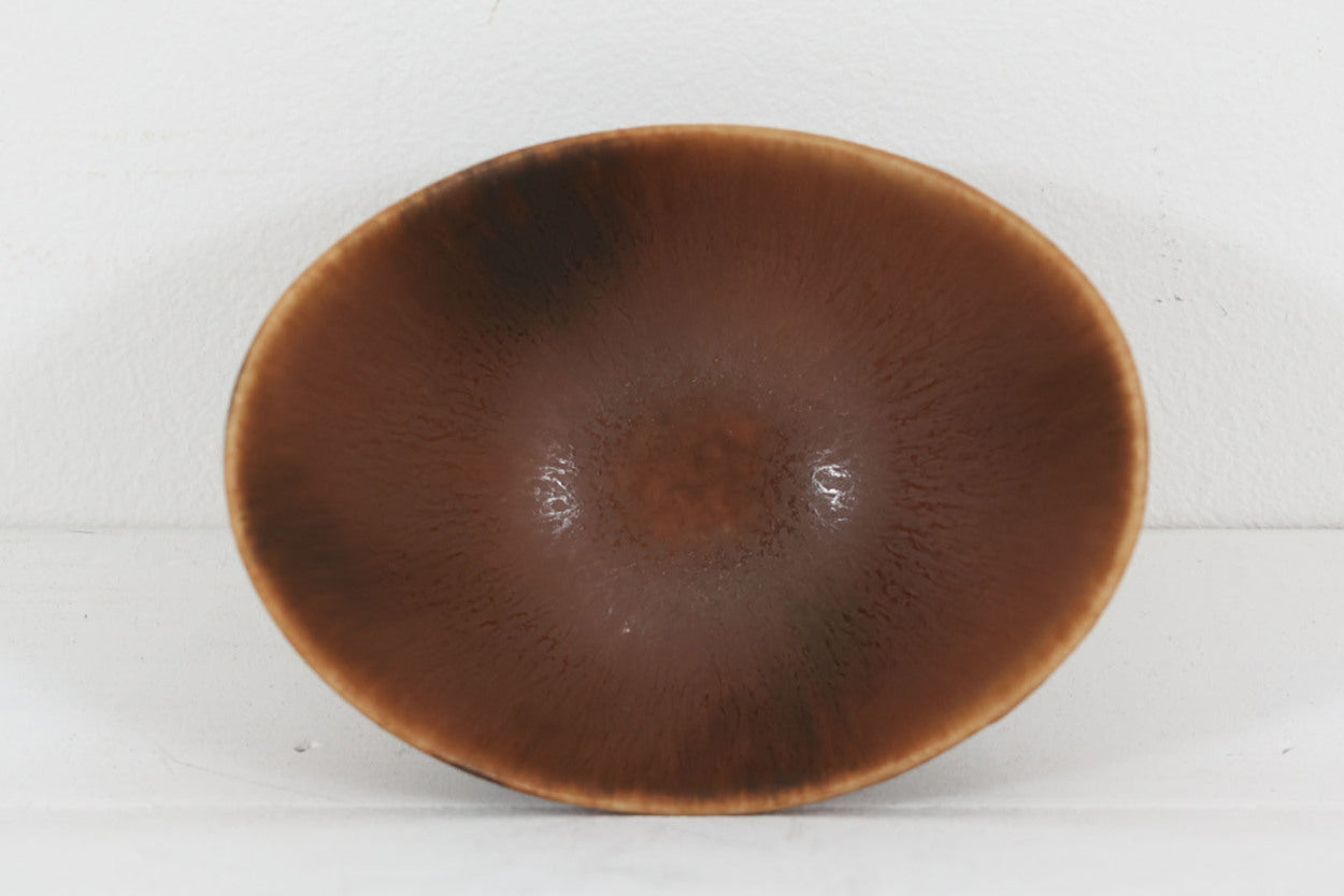 フィンランド人で彫刻家の父と、デンマーク人で陶芸家の母の元に育つGunnarNylundはデンマークで建築を学んだ後、Bing&amp;amp;Grondahl窯、スウェーデンRorstrand窯に就業し、多くの作品を生み出しています。彼の作品は独特な流線型と釉薬が特徴で世界中で重宝されています。AROボウルは彼の最も代表的な作品で、その緩やかな美しいカーブが特徴です。また、さまざまな表情をみせる釉薬がコレクターにも人気がある理由です。