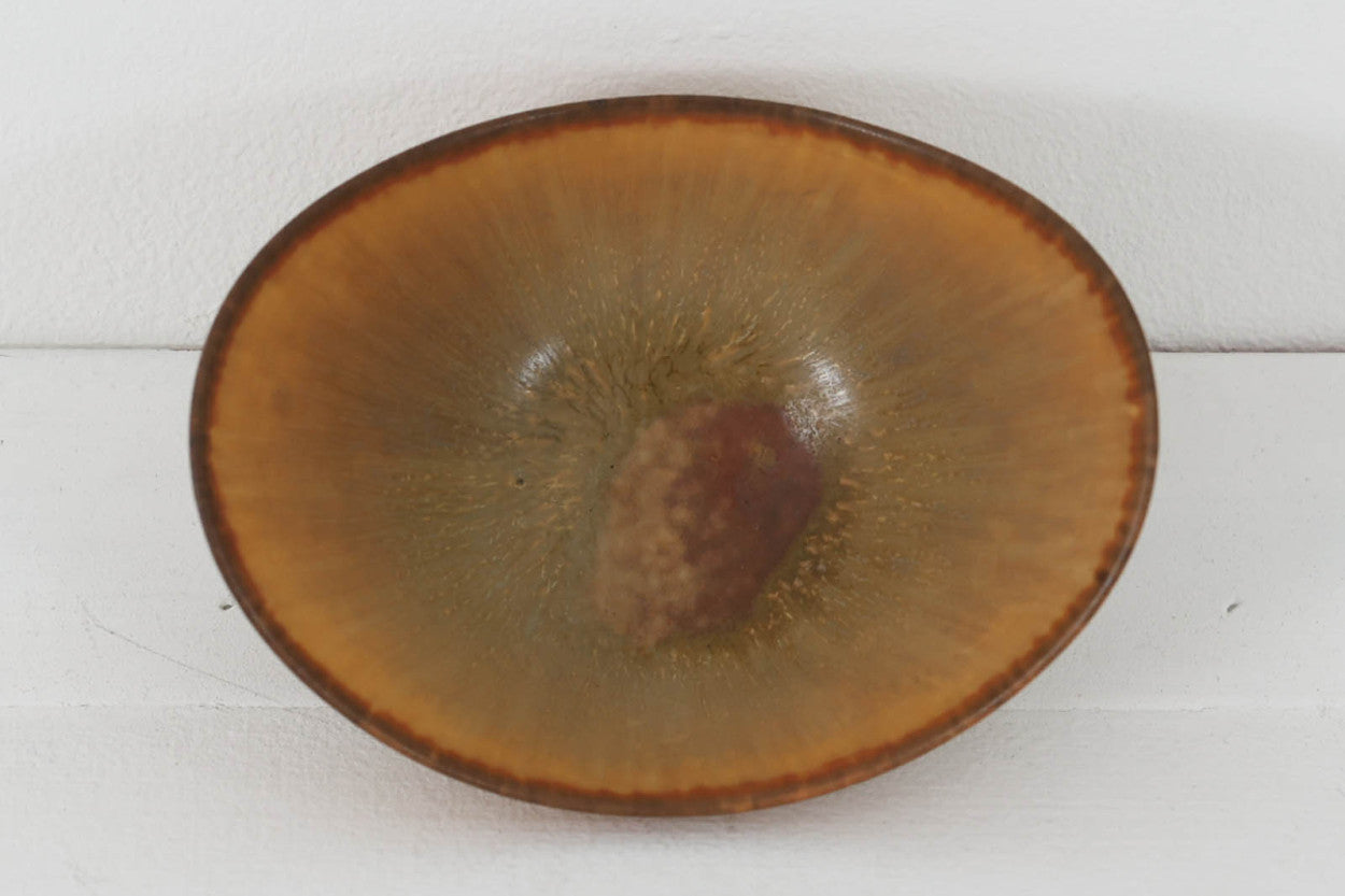 フィンランド人で彫刻家の父と、デンマーク人で陶芸家の母の元に育つGunnarNylundはデンマークで建築を学んだ後、Bing&amp;amp;Grondahl窯、スウェーデンRorstrand窯に就業し、多くの作品を生み出しています。彼の作品は独特な流線型と釉薬が特徴で世界中で重宝されています。AROボウルは彼の最も代表的な作品で、その緩やかな美しいカーブが特徴です。また、さまざまな表情をみせる釉薬がコレクターにも人気がある理由です。